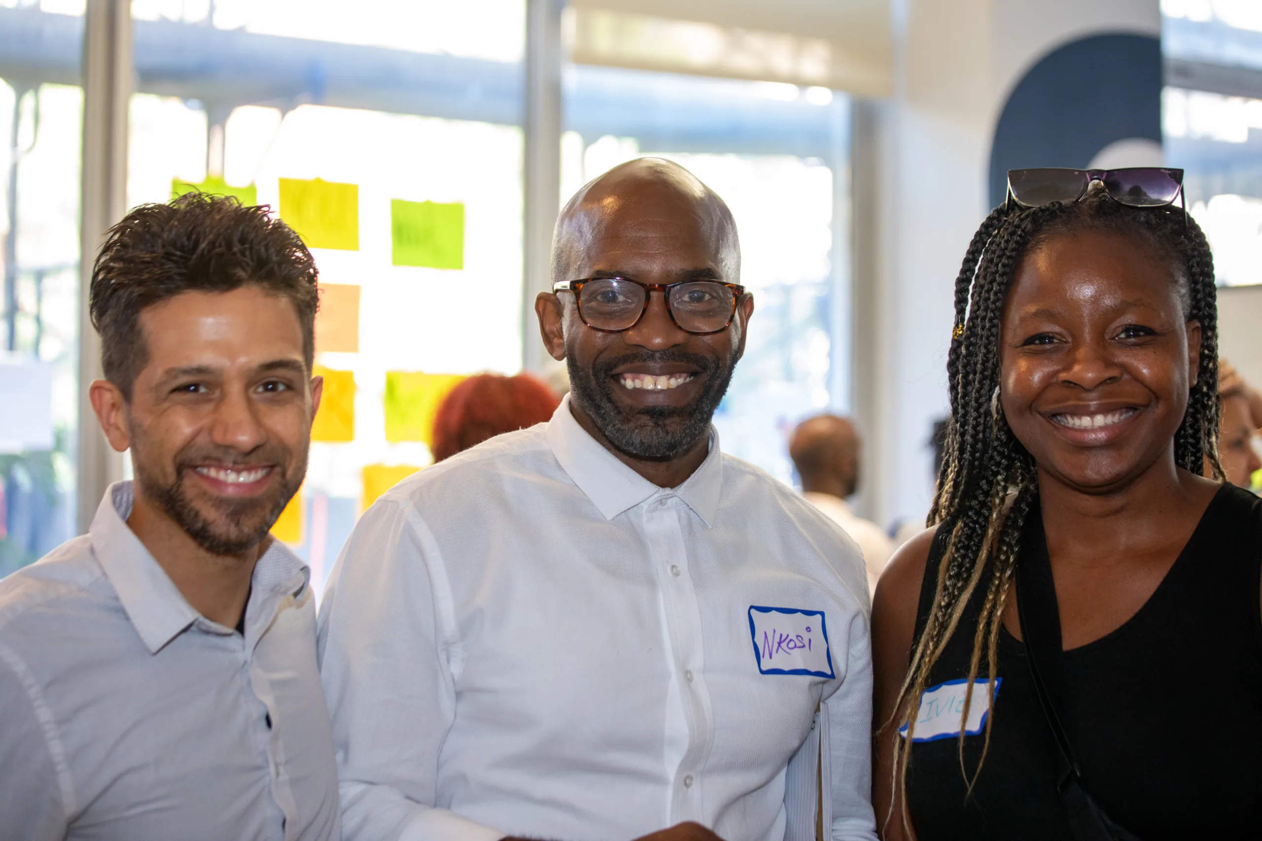 Three people smiling for a photograph.