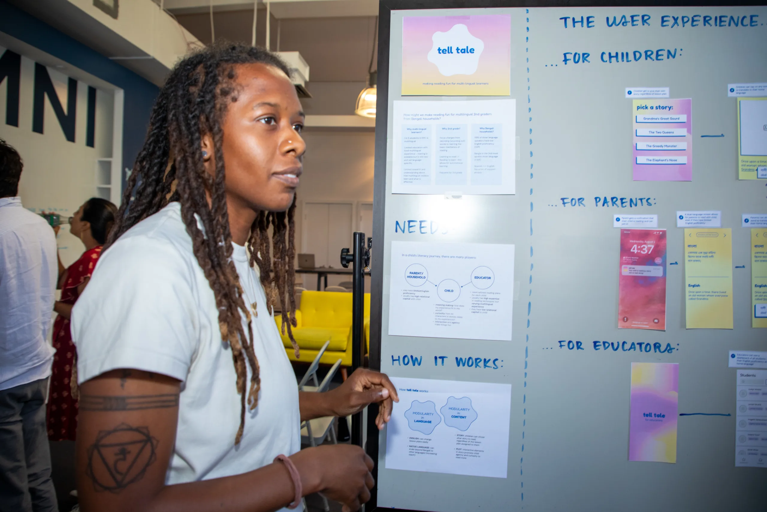 A person presenting using a large white board.