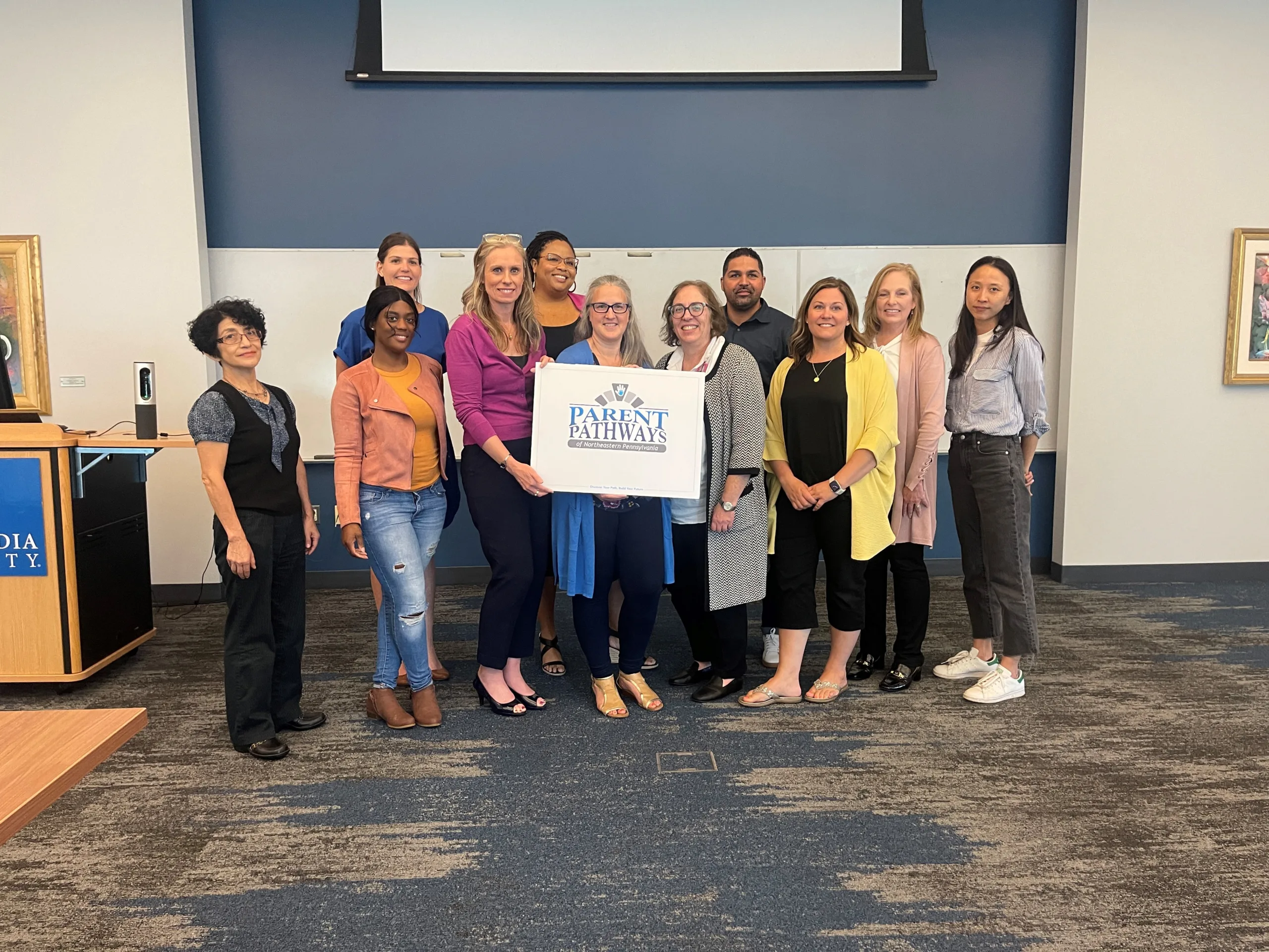 A large group of people posing in an office setting.