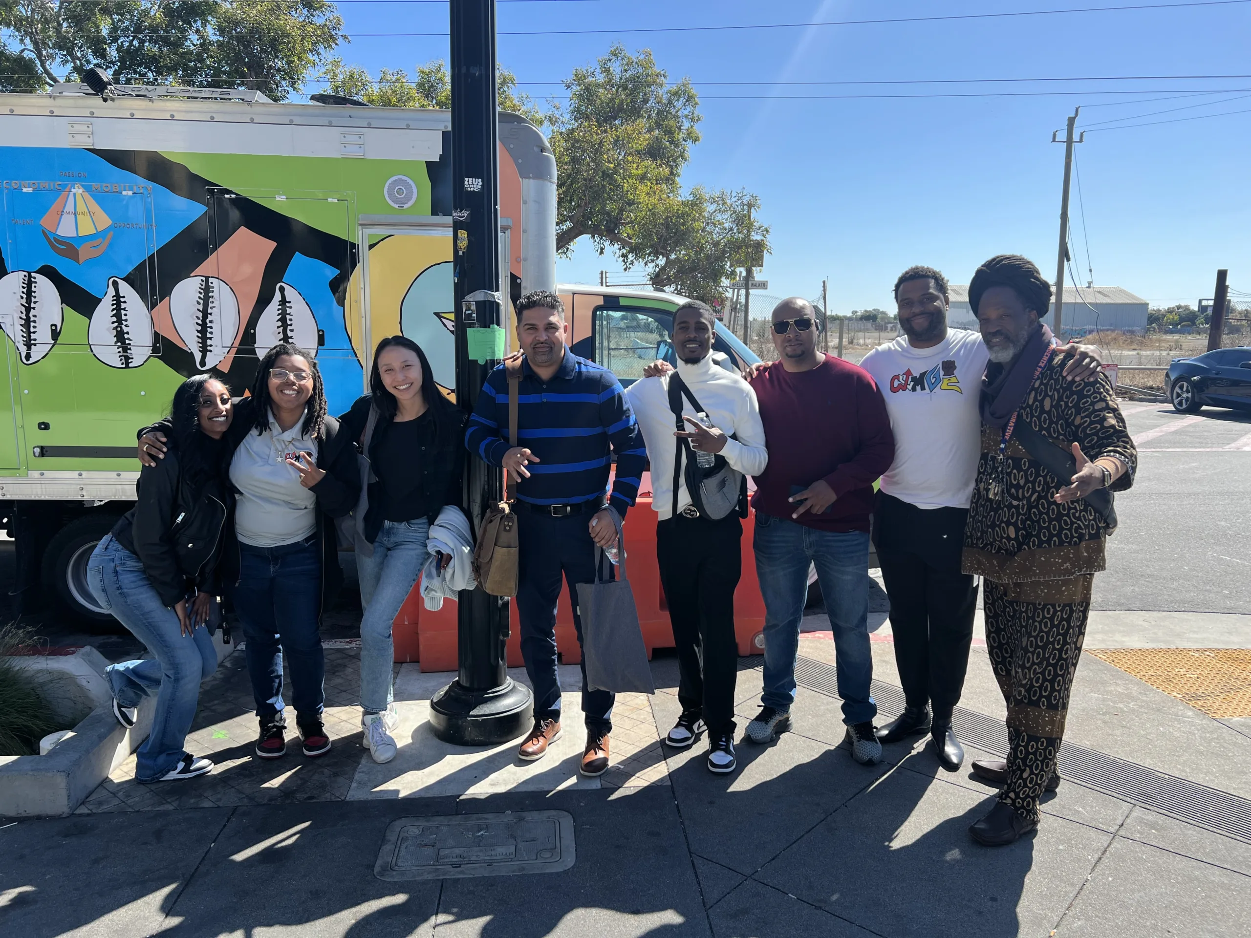 A group of eight people posing for a photo in an outdoor setting.